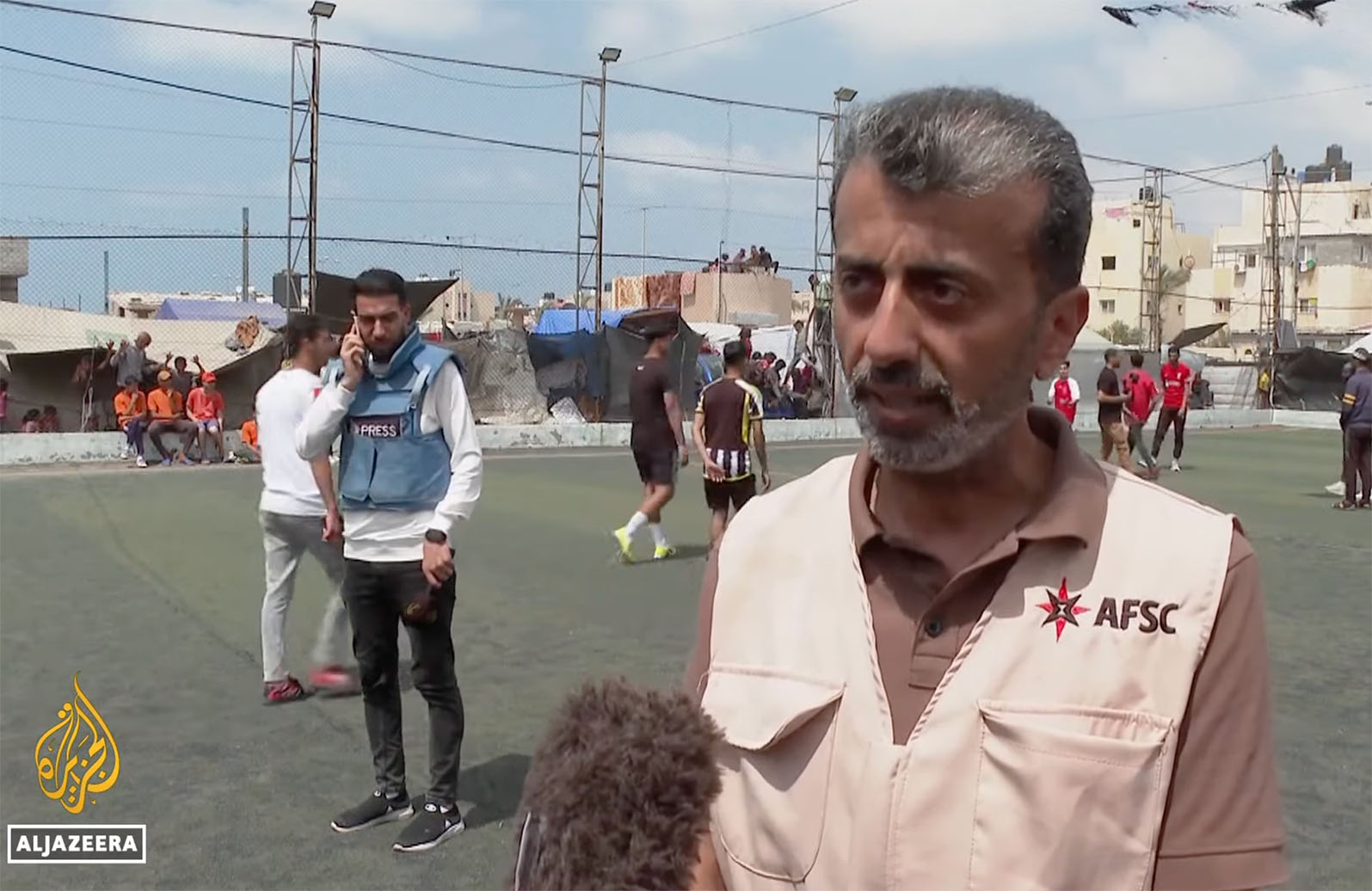 Firas Ramlawi being interviewed on a soccer field in Gaza