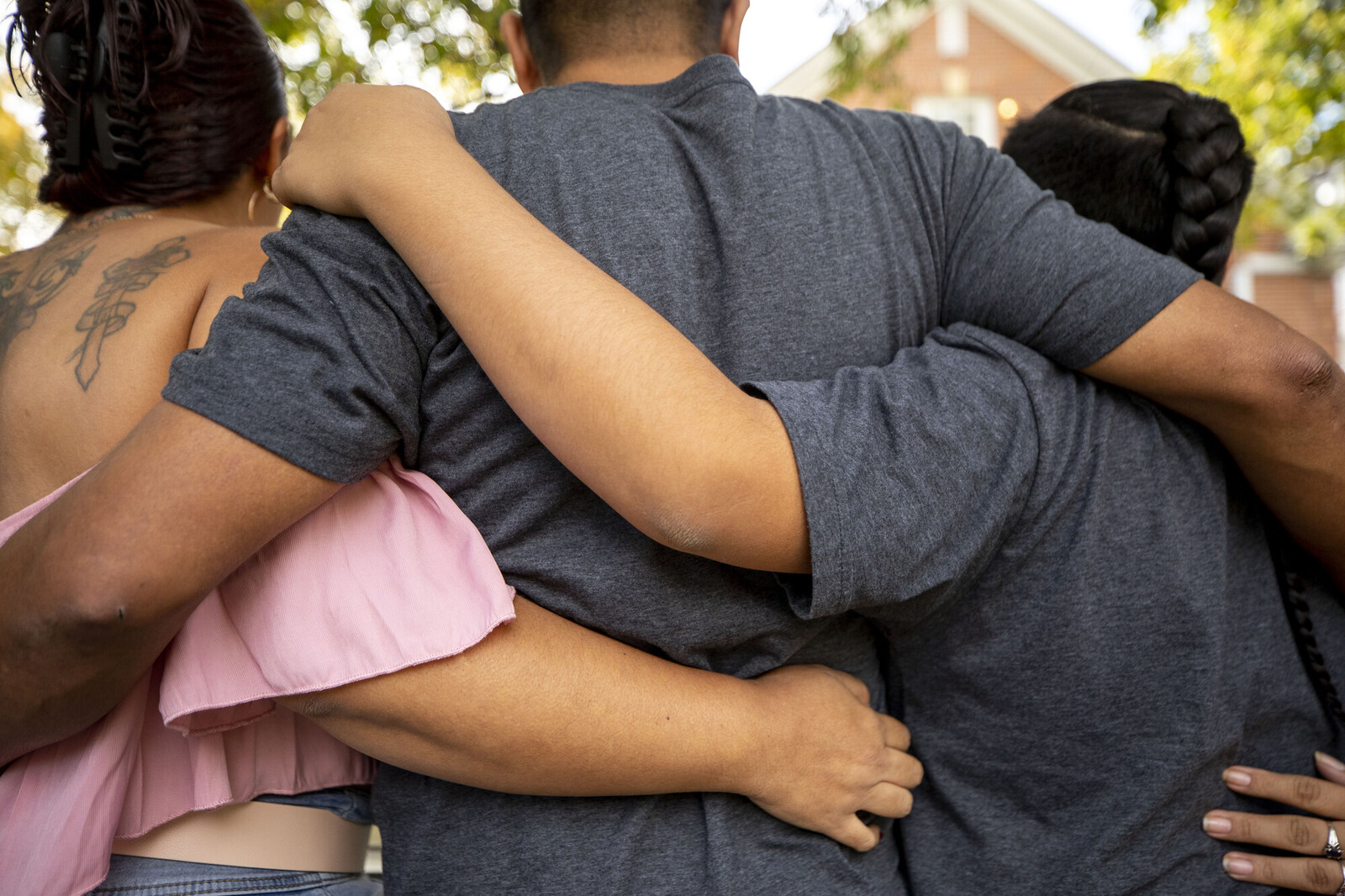 Three family members shown from the back in a group hug