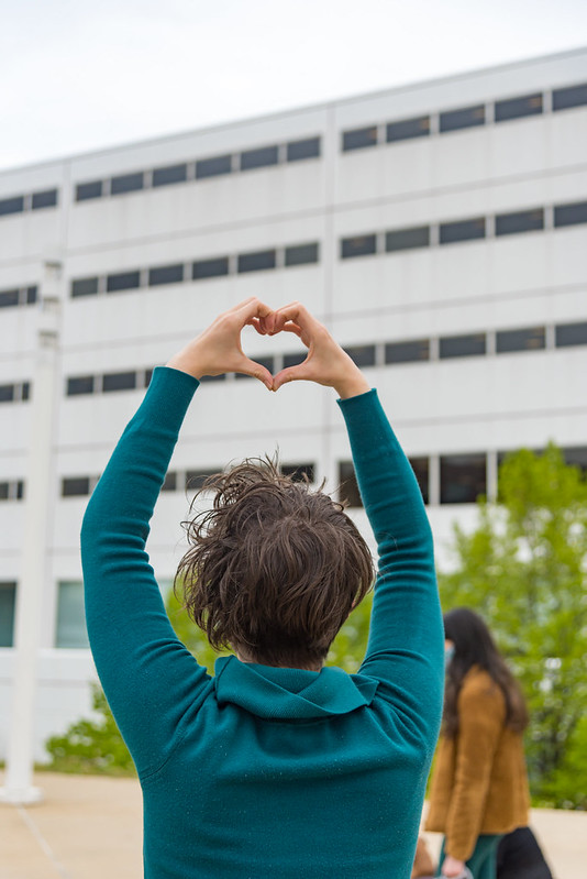 person holding up heart sign in front of juvenile detention center
