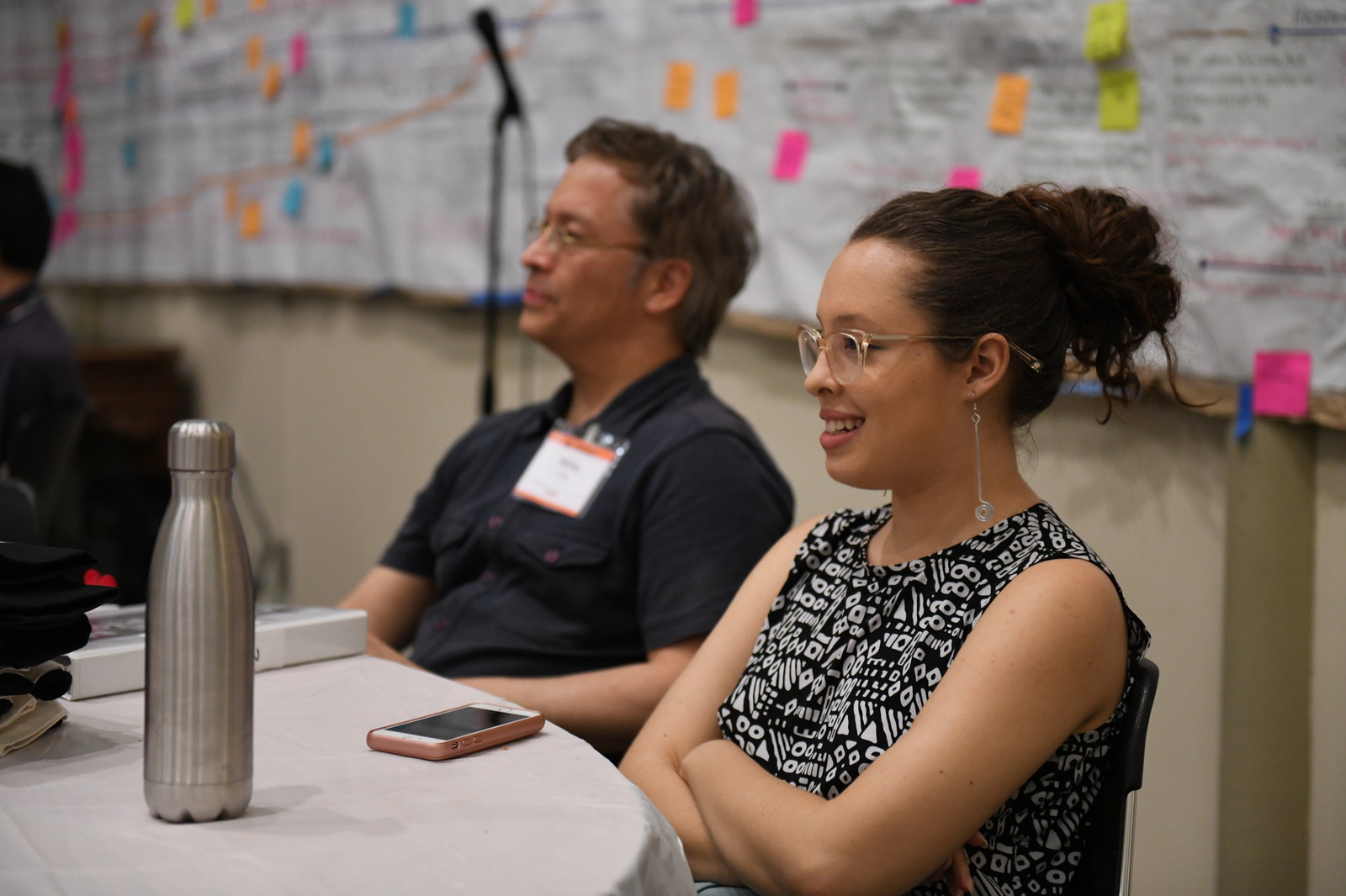 two people sitting at a table and smiling.