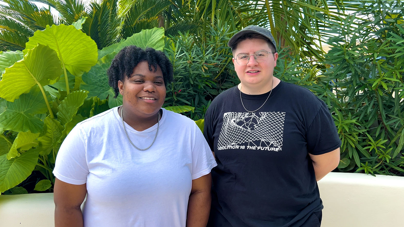Two people standing outdoors looking into the camera