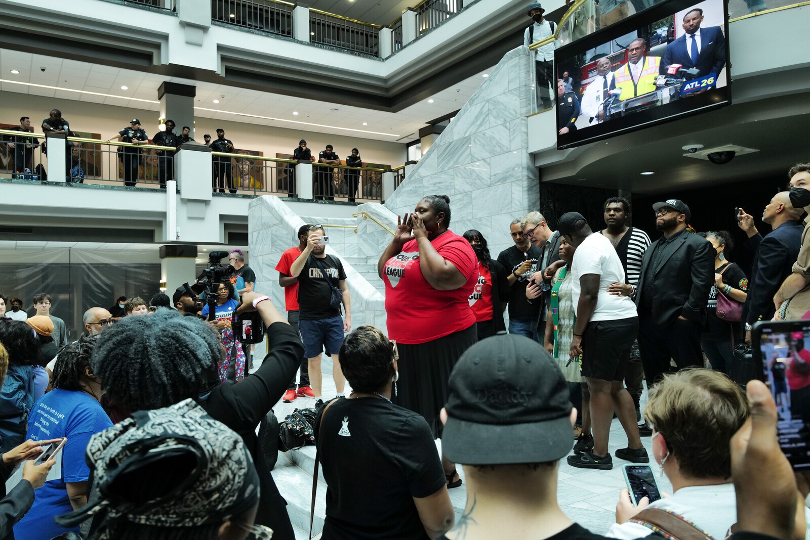 Person talking on stage as crowd looks on