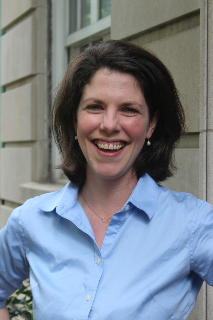 picture of woman with short brown hair and blue collared shirt smiling at camera