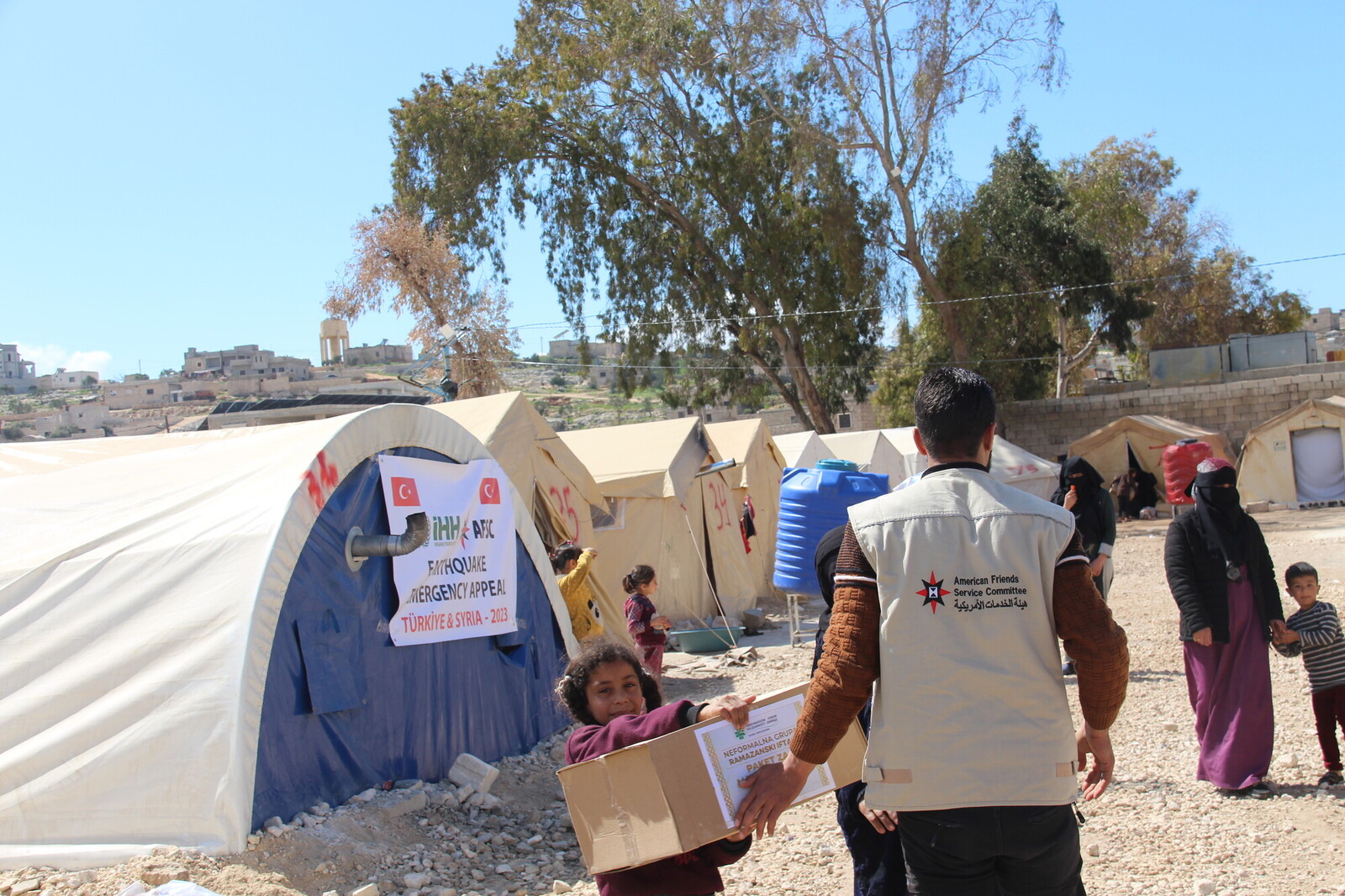 workers delivering aid to people in refugee camp