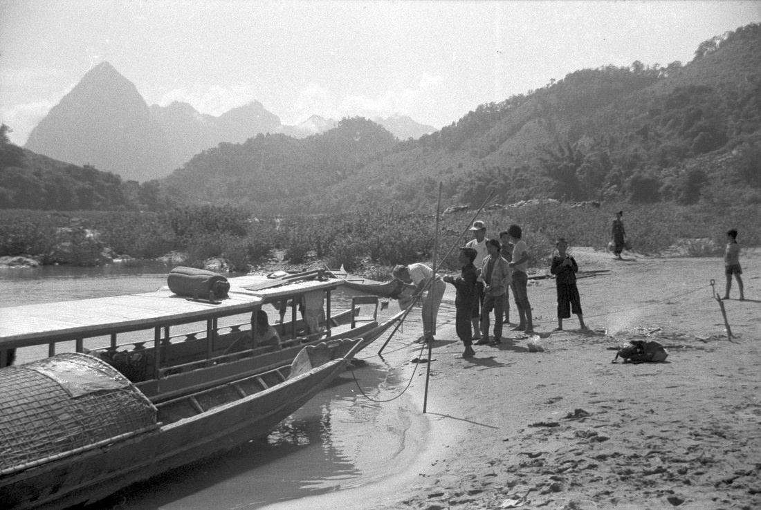 Group of people standing by a boat at the shore