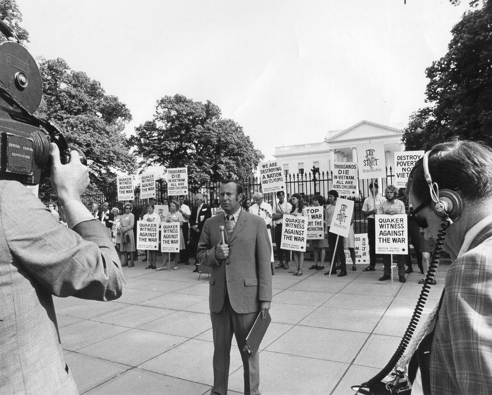 Man being interviewed in front of a group of protesters at the White House