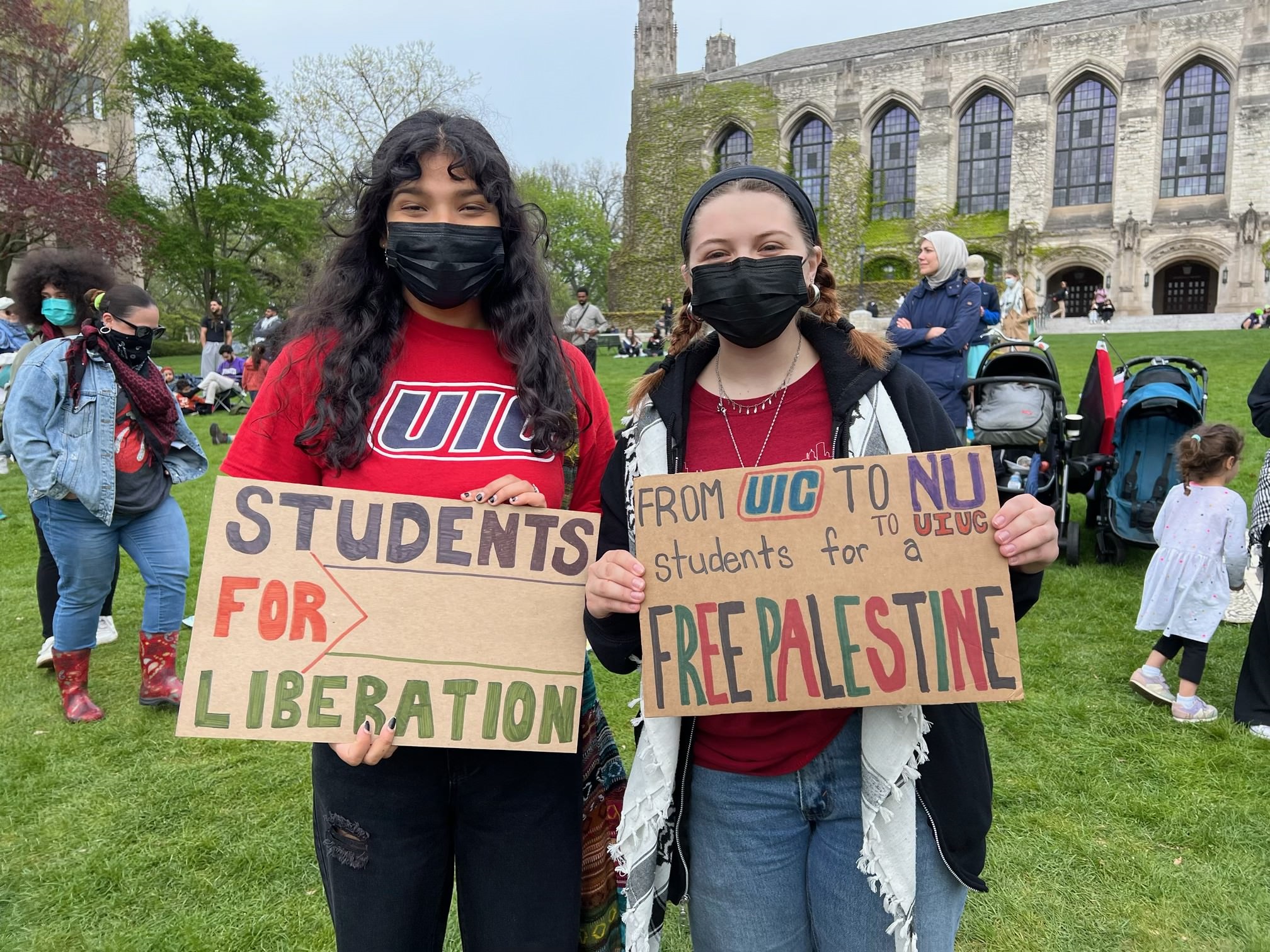 Two women hold cardboard signs about Palestine