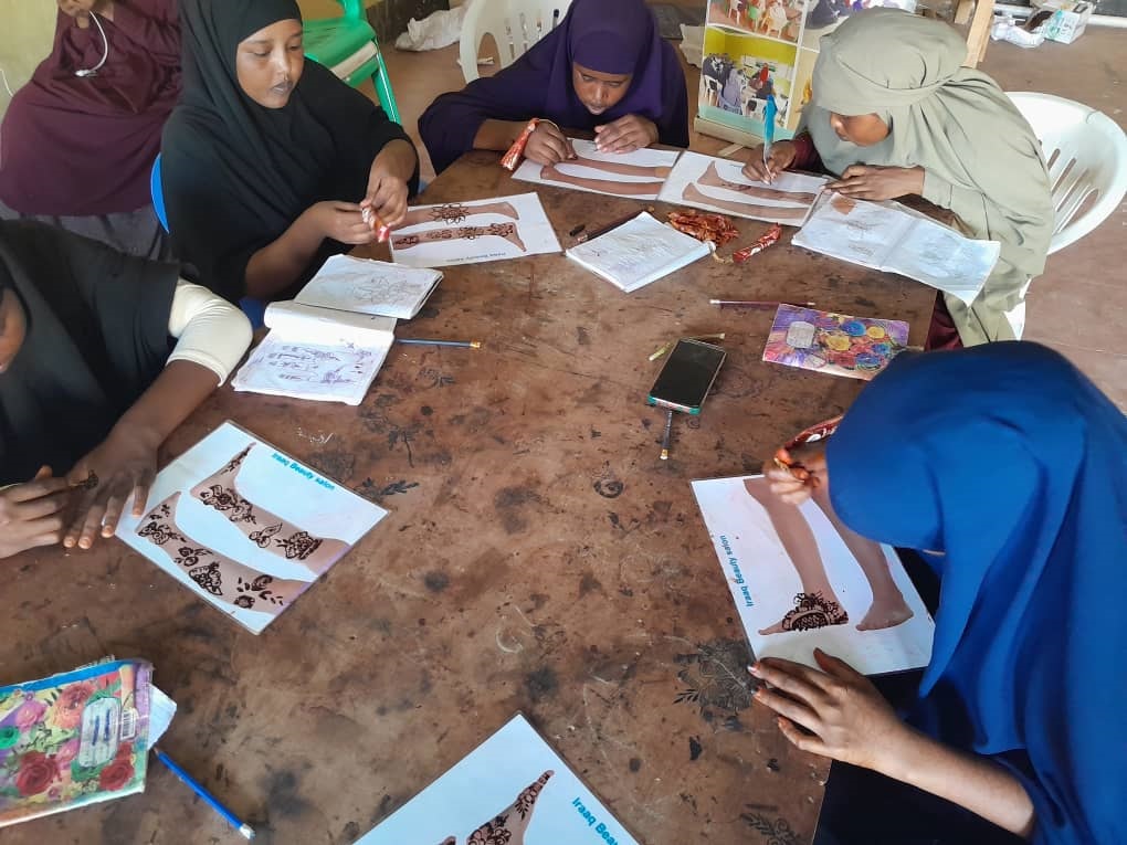group of women around a table drawing