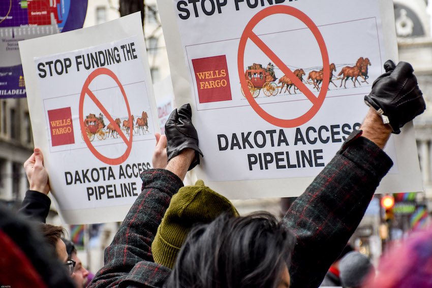 Protestors at a rally, holding signs reading "Stop funding the Dakota Access Pipeline". Flickr user Joe Piette / Creative Commons. 