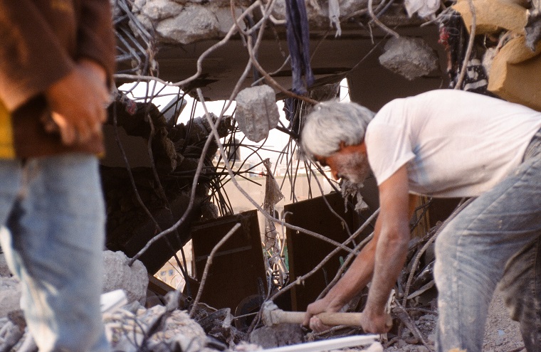 A resident digs out belongings from the ruins of his destroyed home in Jenin. Photo: Mike Merryman-Lotze/AFSC